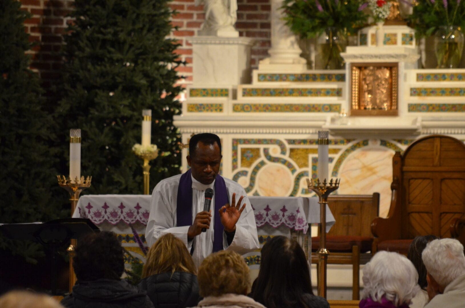 A man in a church giving a sermon to people.