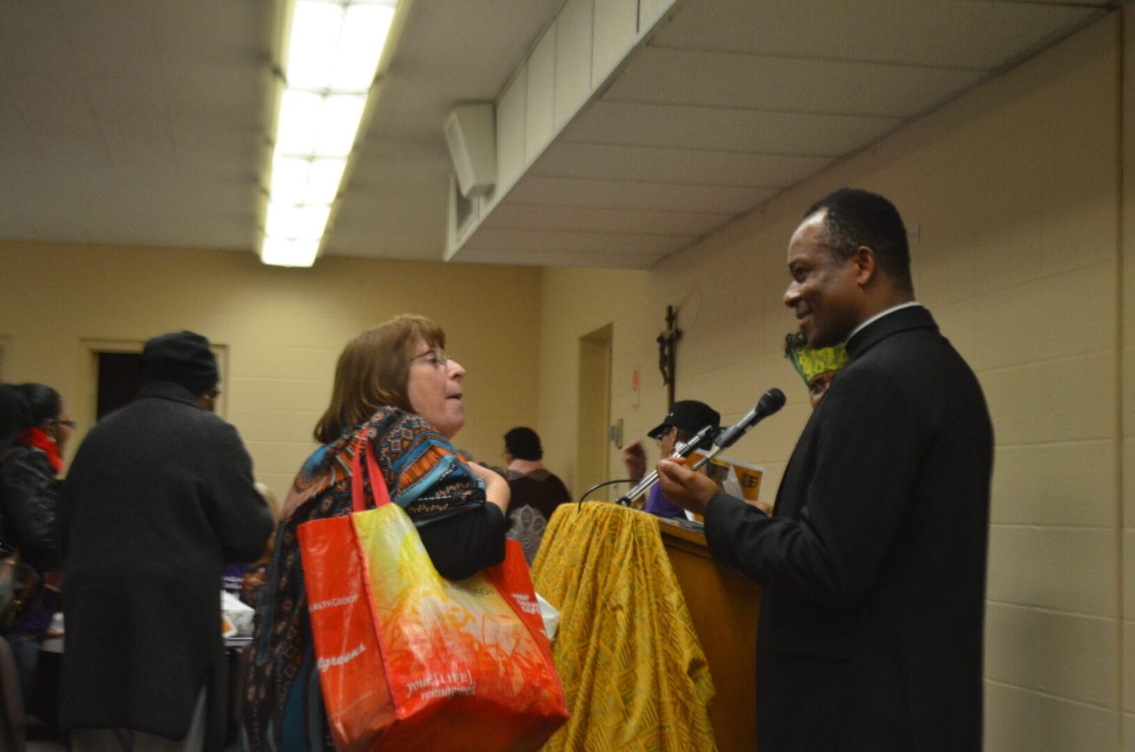 A man talking to a woman holding two bags.