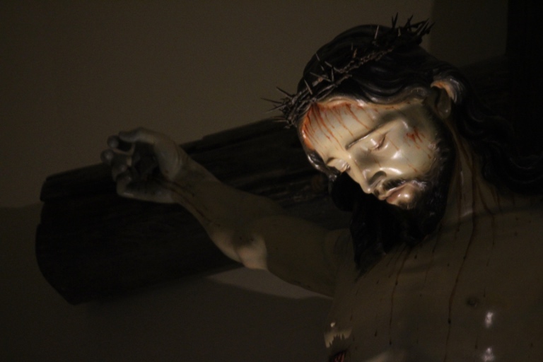 A statue of jesus holding the cross in his hands.