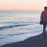 A person walking on the beach with their bag