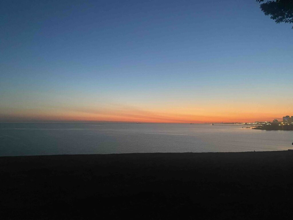 A view of the ocean at sunset from an airplane.