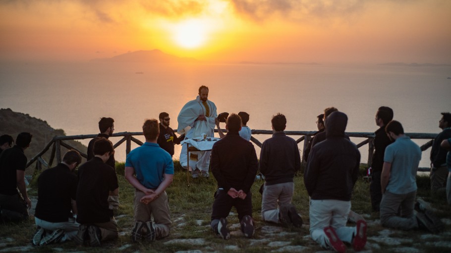 A group of people sitting on top of a hill.