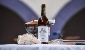 A bottle of wine and some glasses on a table.