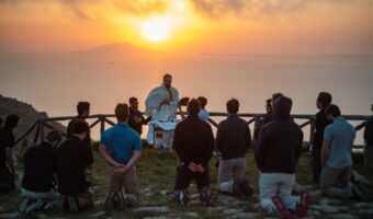 A group of people sitting on top of a hill.