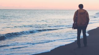 A person walking on the beach with their bag